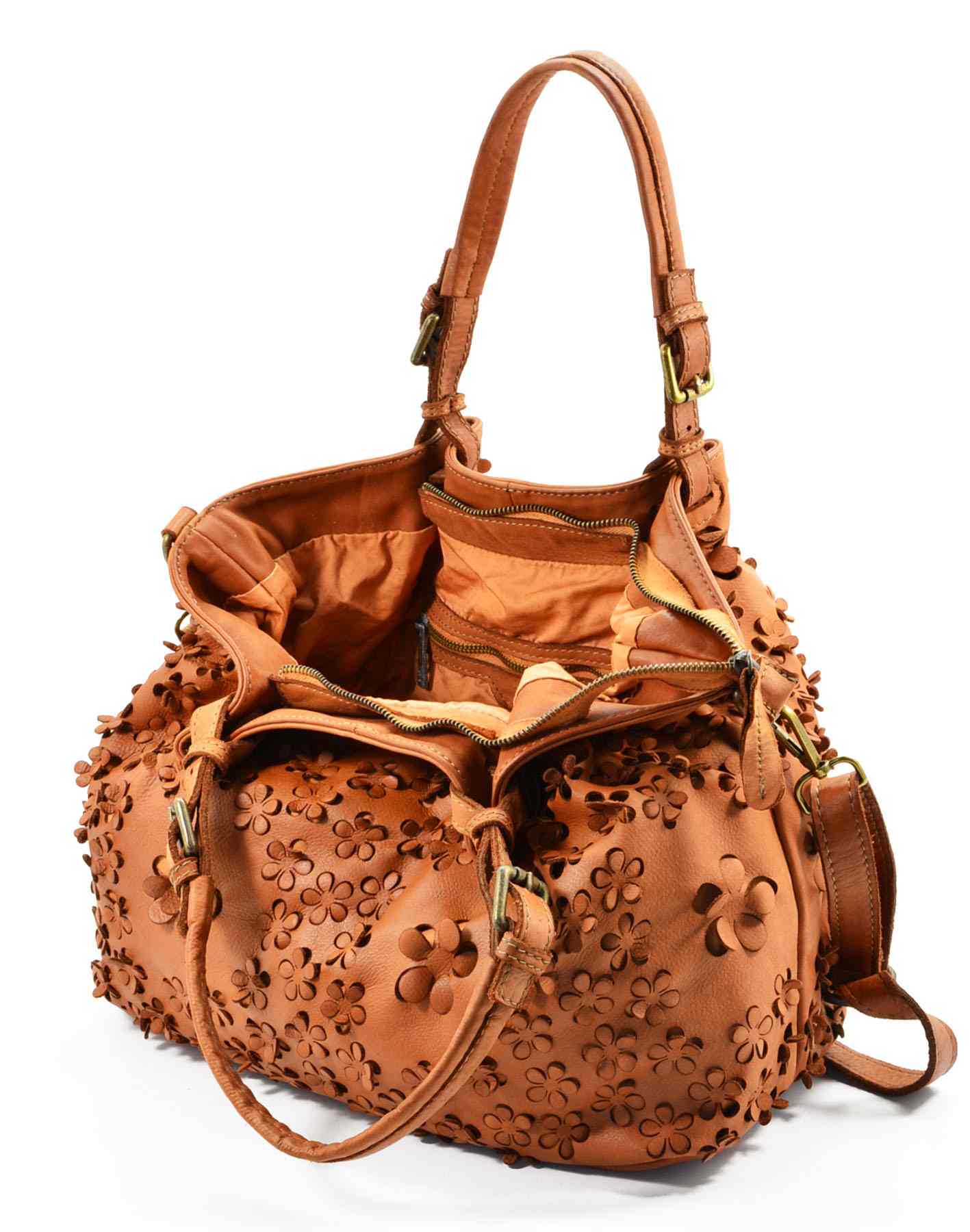 Detaljbild på utskuret blommönster i handväska, mjukt läder